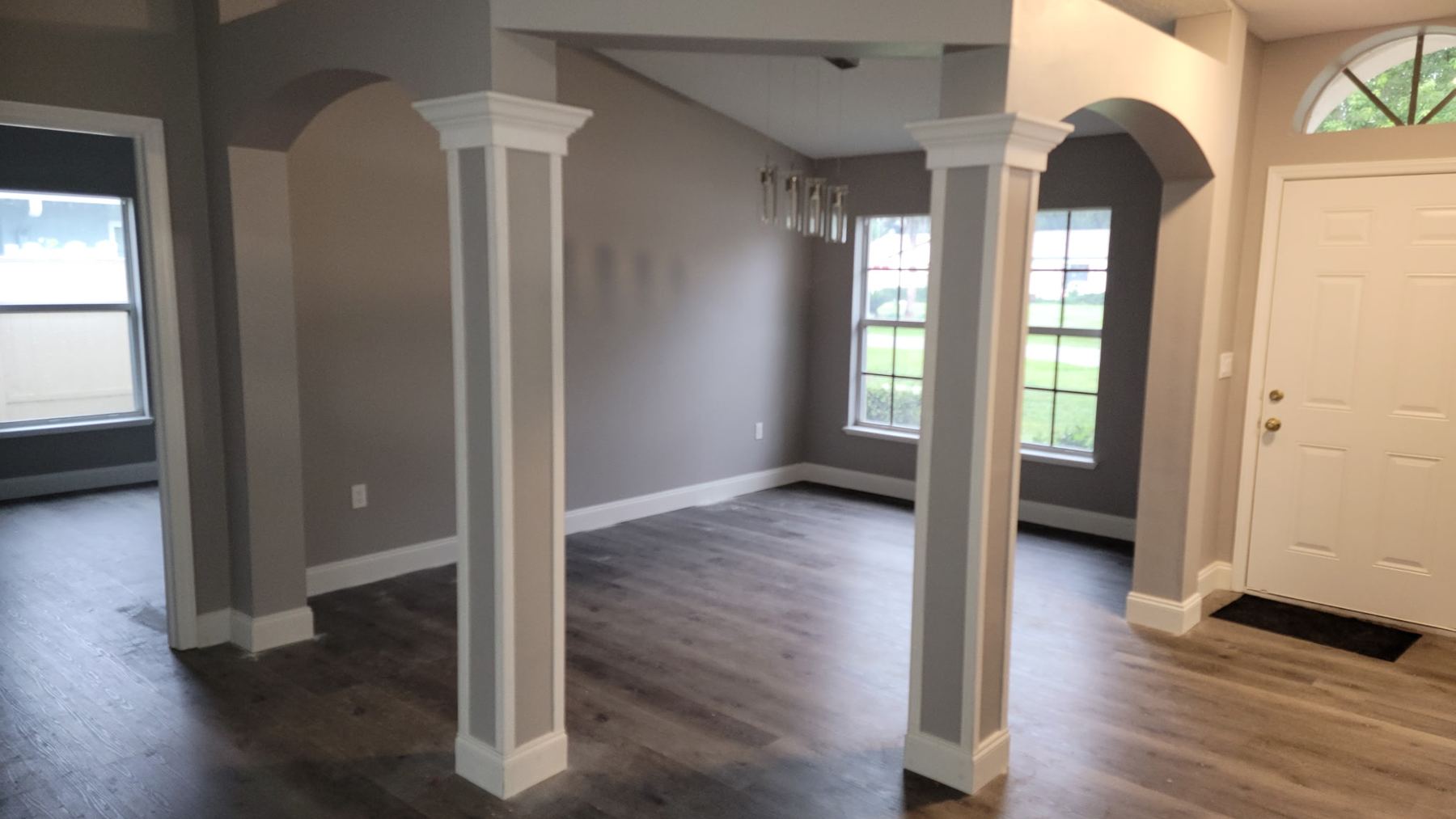 Living room with new trimmed columns, fresh paint, baseboards and vinyl plank flooring